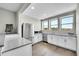 Kitchenette featuring wood floors, stainless steel refrigerator, wine fridge, marble countertops and white cabinetry at 8661 S De Gaulle Ct, Aurora, CO 80016