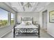 Bright main bedroom with tray ceilings, decorative chandelier, decorative iron bed frame and bedside tables at 8661 S De Gaulle Ct, Aurora, CO 80016