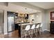 Basement bar area with dark cabinetry, sleek bar stools, and pendant lighting at 14807 Haley Ave, Parker, CO 80134
