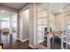 Inviting hallway with dark hardwood floors, leading to a bright office space with French doors and natural light at 14807 Haley Ave, Parker, CO 80134