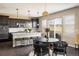 Modern kitchen with dark cabinetry, white granite countertops, stainless steel appliances, and a cozy breakfast nook area at 14807 Haley Ave, Parker, CO 80134