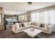 Spacious living room showcasing a comfortable sectional sofa, hardwood floors, and seamlessly connected with a modern kitchen at 14807 Haley Ave, Parker, CO 80134