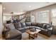 Spacious living room with a large sectional sofa, natural light, and a view of the staircase at 14807 Haley Ave, Parker, CO 80134