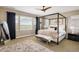 Tranquil main bedroom with a four-poster bed, large windows offering scenic views, and elegant decor for relaxation at 14807 Haley Ave, Parker, CO 80134