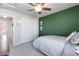 Well-lit bedroom featuring soft carpet, ceiling fan, green accent wall and a closet at 12759 Buffington Trl, Parker, CO 80134