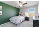 Cozy bedroom with green accent wall, ceiling fan, and a comfortable bed, offering a relaxing and stylish retreat at 12759 Buffington Trl, Parker, CO 80134