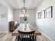 This dining room is decorated with unique artwork and features an eye-catching modern light fixture and a long wood dining table at 12759 Buffington Trl, Parker, CO 80134