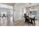 Open dining room with wood table, modern light fixture, and view into the living area at 12759 Buffington Trl, Parker, CO 80134
