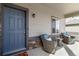 Inviting covered front porch featuring cozy wicker chairs with blue cushions, perfect for relaxing outdoors at 12759 Buffington Trl, Parker, CO 80134