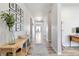 Bright, long hallway with light wood floors, neutral walls, and decorative console table with decor at 12759 Buffington Trl, Parker, CO 80134
