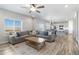 Open-concept living room flows to kitchen with large windows, wood floors and neutral color palette at 12759 Buffington Trl, Parker, CO 80134