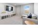 Cozy living room featuring comfortable seating, a large TV, a desk, and toy storage with natural light through a window at 12759 Buffington Trl, Parker, CO 80134