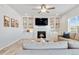 Bright living room with built-in shelving, a cozy fireplace, and modern ceiling fan at 12759 Buffington Trl, Parker, CO 80134