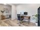 This home office offers a quiet workspace with wood desk and ample natural light and minimalist decorations to help you focus at 12759 Buffington Trl, Parker, CO 80134
