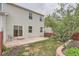 An outdoor view of the backyard with a patio, lawn, and landscaping surrounding the house at 5522 S Quemoy Cir, Aurora, CO 80015