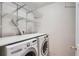 Laundry room with washer, dryer, overhead shelving and white walls at 5522 S Quemoy Cir, Aurora, CO 80015