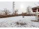 Snowy backyard with a fenced perimeter and a covered patio at 5332 Granby St, Denver, CO 80239