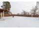 Snowy backyard with a fenced perimeter and a covered patio at 5332 Granby St, Denver, CO 80239