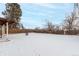 Snowy backyard with a fenced perimeter and a covered patio at 5332 Granby St, Denver, CO 80239