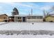 Ranch style home with gray siding, snowy yard, and covered carport at 5332 Granby St, Denver, CO 80239