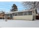 Gray ranch style home with snowy front yard and landscaping at 5332 Granby St, Denver, CO 80239