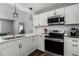 Modern kitchen with white cabinets, stainless steel appliances, and quartz countertops at 5332 Granby St, Denver, CO 80239