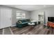 Living room features a green sectional sofa, wood-look floors, and a large mirror at 5332 Granby St, Denver, CO 80239