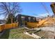 Exterior view of townhome showing fenced yard, lawn, and garden beds at 2890 S Sherman St, Englewood, CO 80113