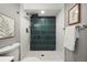 Modern shower with dark teal tiling, white tile surround, and pebble tile floor at 2890 S Sherman St, Englewood, CO 80113