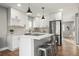 Modern kitchen with stainless steel appliances, white cabinetry, and stylish island with bar stools at 2890 S Sherman St, Englewood, CO 80113