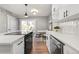 Bright kitchen featuring stainless steel appliances, white cabinetry, and a dining area at 2890 S Sherman St, Englewood, CO 80113