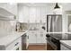 Modern kitchen featuring white cabinetry, stainless steel appliances, and a stylish backsplash at 2890 S Sherman St, Englewood, CO 80113