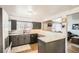 Modern kitchen featuring sleek countertops, gray cabinetry, stainless steel appliances, and a serving hatch at 6033 Hoyt Ct, Arvada, CO 80004