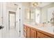Traditional bathroom with wood vanity, marble countertops, and a large mirror at 27 Tamarade Dr, Littleton, CO 80127