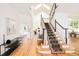 Inviting foyer with hardwood floors and a grand staircase featuring a carpet runner at 27 Tamarade Dr, Littleton, CO 80127