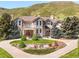 Stunning stone home with a manicured lawn, mature trees and an attractive circular drive at 27 Tamarade Dr, Littleton, CO 80127
