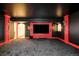 Home theater room with black ceiling, red trim, and a large screen TV at 27 Tamarade Dr, Littleton, CO 80127