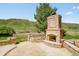 Inviting outdoor brick fireplace on a stamped concrete patio with picturesque mountain views, perfect for entertaining at 27 Tamarade Dr, Littleton, CO 80127