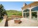 Beautiful patio with mountain views, stone fire pit, and access to indoor living through sliding glass doors at 27 Tamarade Dr, Littleton, CO 80127