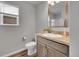 Bright bathroom with wood-look flooring, a wood vanity, and brushed nickel finishes at 847 Great Plains Ave, Berthoud, CO 80513