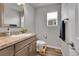 Bright half bath with wood-look flooring, a wood vanity, and brushed nickel finishes at 847 Great Plains Ave, Berthoud, CO 80513