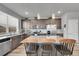 Well-lit kitchen with a large island and stainless steel appliances, complete with granite countertops and dark cabinets at 847 Great Plains Ave, Berthoud, CO 80513