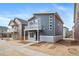 Two story home with a balcony, gray siding, well-manicured lawn, and sidewalk at 46558 Avery Ln, Bennett, CO 80102