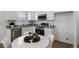 Bright kitchen featuring white cabinets, stainless steel appliances, granite countertops, and a dining area with a round table at 46558 Avery Ln, Bennett, CO 80102
