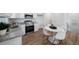 A modern kitchen with white cabinets, stainless steel appliances, granite countertops, and a dining area with white round table at 46558 Avery Ln, Bennett, CO 80102