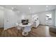 Well-lit living room with light colored furniture and floors, including a dining area with a round table and chairs at 46558 Avery Ln, Bennett, CO 80102