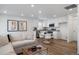 Open-concept living area with a kitchen, dining area and plenty of natural light featuring modern furnishings and wood-style floors at 46558 Avery Ln, Bennett, CO 80102