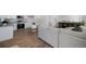 Open-concept living area with a kitchen, dining area and staircase featuring modern furnishings and wood-style floors at 46558 Avery Ln, Bennett, CO 80102