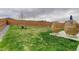 Expansive backyard features lush green grass, a wooden fence, and stylish patio furniture at 635 Silver Rock Trl, Castle Rock, CO 80104