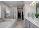 Luxurious bathroom featuring a soaking tub, walk-in shower, and double vanity at 635 Silver Rock Trl, Castle Rock, CO 80104